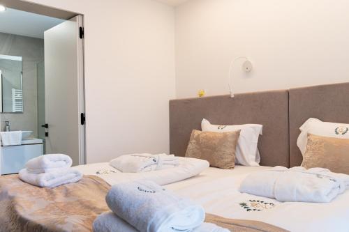 1 dormitorio con 2 camas y toallas. en Top Apartments Opatija, en Dobreć