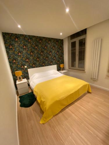 ein Schlafzimmer mit einem Bett mit einer gelben Decke in der Unterkunft Cozy Flat in Brüssel