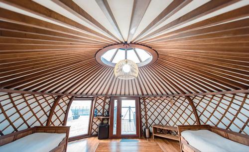 Cette chambre comprend deux lits et un plafond orné d'un lustre. dans l'établissement Red Rock Resort, à Oulan-Bator