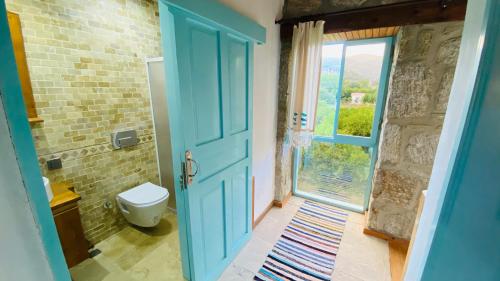 baño con puerta azul y aseo en Close to sea in The Village of Bodrum/Mazı Stone House, en Bodrum City