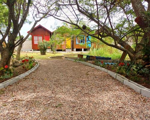 賓海洛的住宿－Recanto Cabanas，红色房子前面的砂石车道