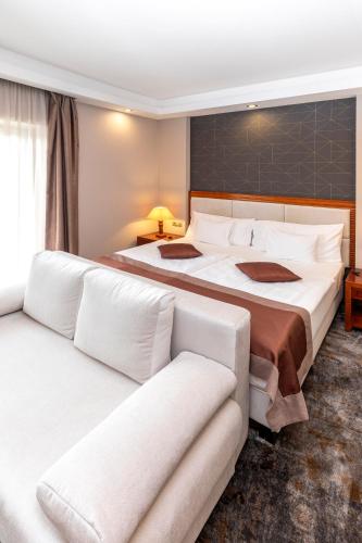 two beds in a hotel room with white pillows at Colosseum Hotel in Mórahalom
