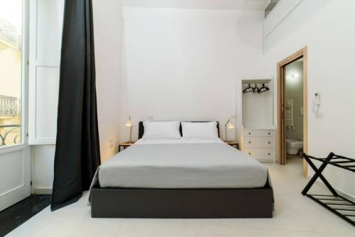 - une chambre avec un grand lit blanc et une fenêtre dans l'établissement luxury and comfort in historic Salerno, à Salerne