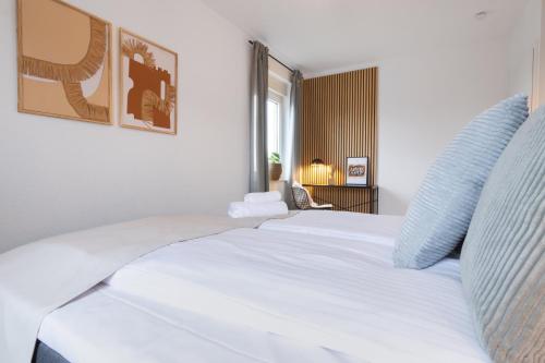 a white bed in a room with a window at Stilvolle 3-Zimmer Apartments I home2share in Lengerich