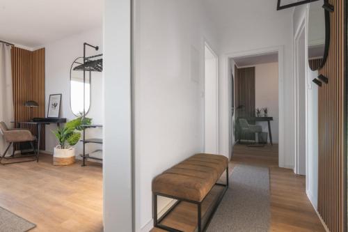 a living room with a stool in the middle of a room at Stilvolle 3-Zimmer Apartments I home2share in Lengerich
