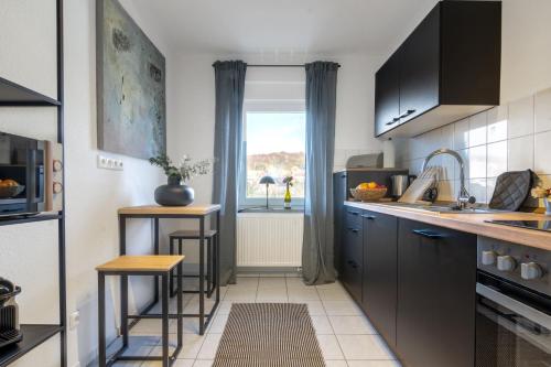 a small kitchen with a counter and a window at Stilvolle 3-Zimmer Apartments I home2share in Lengerich