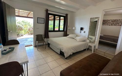 a bedroom with a bed and a living room at Les Bungalows de Figha in Tarcu