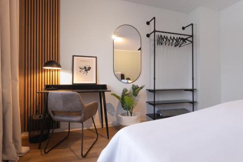 a bedroom with a desk and a mirror and a chair at Stilvolle 3-Zimmer Apartments I home2share in Lengerich