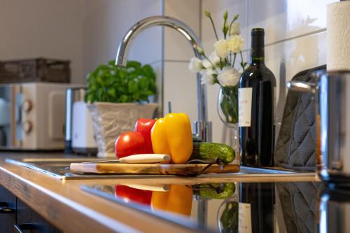 a kitchen counter with fruits and vegetables on a cutting board at Stilvolle 3-Zimmer Apartments I home2share in Lengerich