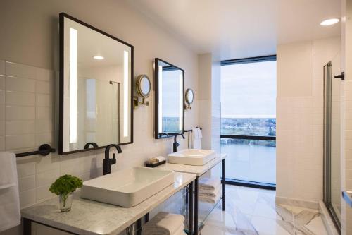 a bathroom with two sinks and two mirrors at Renaissance Toledo Downtown Hotel in Toledo