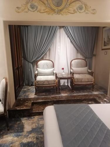 a living room with two chairs and a table at Golden Inn Hotel in Cairo