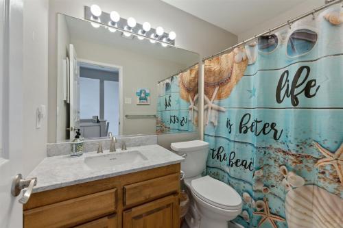 a bathroom with a sink and a toilet and a shower curtain at 116 Austin Ave in Wildwood