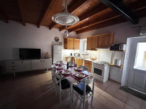 uma cozinha com uma mesa com cadeiras e uma cozinha com electrodomésticos brancos em Tolis House em Corfu Town
