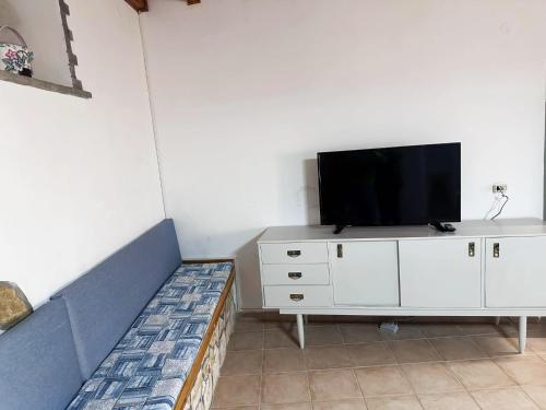uma sala de estar com um sofá e uma televisão num armário em Tolis House em Corfu Town