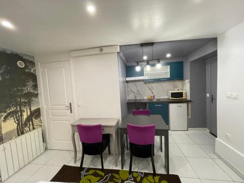 een keuken met een tafel en paarse stoelen bij Studio confortable 5’ metro in Vitry-sur-Seine