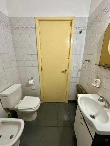 łazienka z toaletą i żółtymi drzwiami w obiekcie DPTO 3 AMB w mieście Mar del Plata
