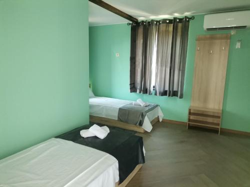 two beds in a room with blue walls at Къща "Конакъ" in Kyustendil