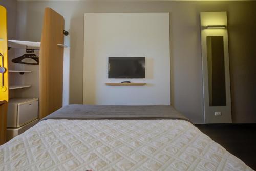 um quarto com uma cama e uma televisão na parede em Rio hotel by Bourbon Indaiatuba Viracopos em Indaiatuba