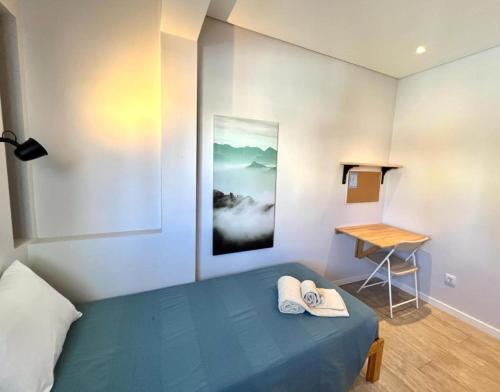 a bedroom with a blue bed and a desk at Campus 121 - Rooms in Faro