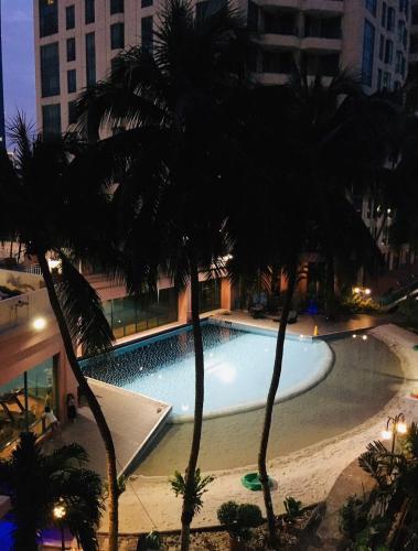 einen Pool mit Palmen in einer Stadt in der Unterkunft casablanca 1 in Jakarta