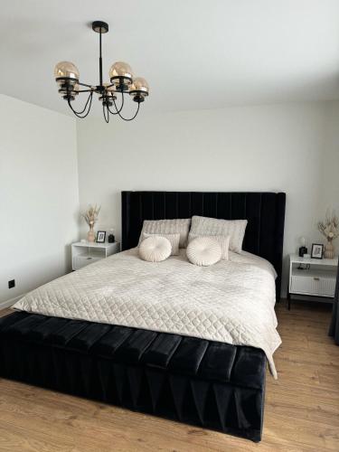 a bedroom with a large black bed with two pillows at Sea Oasis apartment in Liepāja