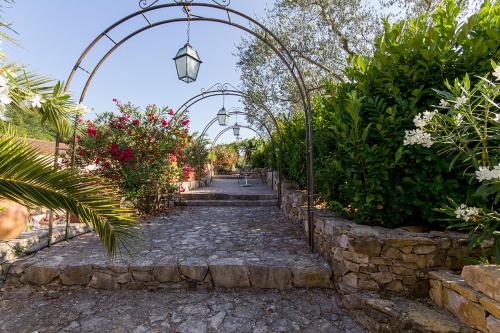 a stone path with an arch in a garden at La Bastide de Valbonne in Valbonne