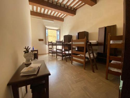 Ostello San Marco Cortona في كورتونا: غرفة معيشة مع طاولة وبعض الكراسي