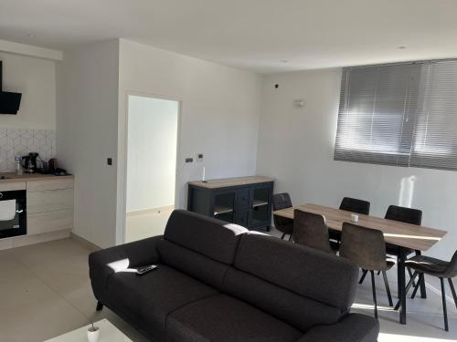 un salon avec un canapé et une table dans l'établissement MIMOSAS RESIDENCE P3, à Juvignac