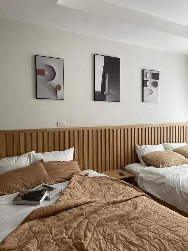1 dormitorio con 2 camas y cuadros en la pared en Charlotte Boutique - Căn hộ cao cấp cách biển chỉ 3p đi bộ en Phú An