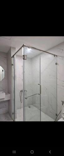 a shower with a glass door in a bathroom at Charlotte Boutique - Căn hộ cao cấp cách biển chỉ 3p đi bộ in Phú An