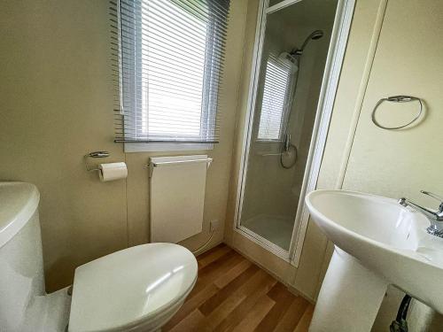 ein Bad mit einem WC, einem Waschbecken und einer Dusche in der Unterkunft Great Caravan At Breydon Water Holiday Park, Ref 10086b in Belton