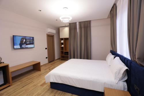 ティラナにあるResidence Inn Hotelのベッドとテレビ付きのホテルルーム