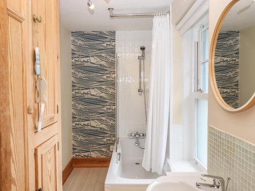 Un baño con bañera, lavabo y espejo. en Topsail, en Dartmouth