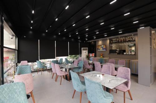 um restaurante com cadeiras e mesas cor-de-rosa e azul em Residence Inn Hotel em Tirana