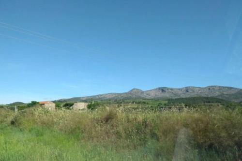 a field of grass with mountains in the background at Appartement spacieux in Cases-de-Pène