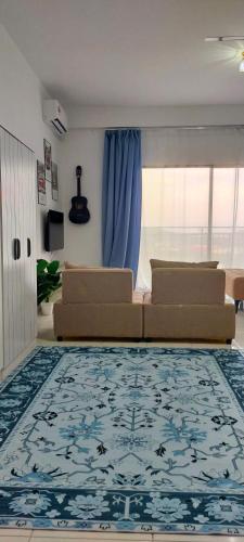 a living room with two couches and a blue rug at Camelia youth city nilai studio residence 5 pax. in Nilai