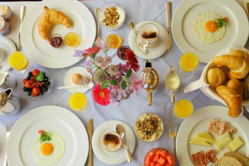 a table full of breakfast foods and orange juice at Hotel Steffani in St. Moritz