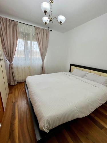 sypialnia z białym łóżkiem i oknem w obiekcie Cozy Apartment w mieście Zalău