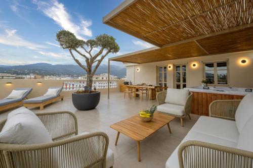 a patio with chairs and a table and a tree at Balcony Luxury Apartment Kalamata in Kalamata