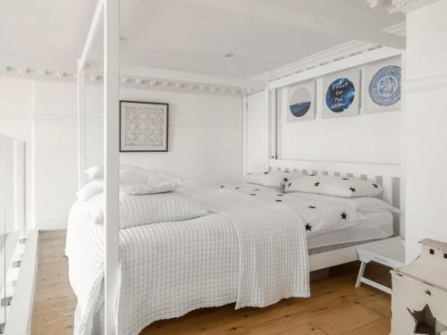 una camera da letto bianca con un letto bianco e pareti bianche di The Little Beach House a Brighton & Hove