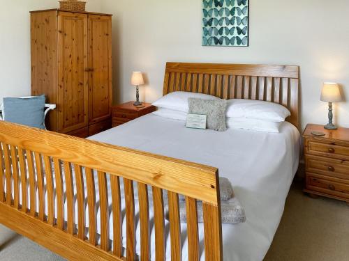 a bedroom with a bed and a wooden crib at Kirnan Cottage in Kilmichael Glassary