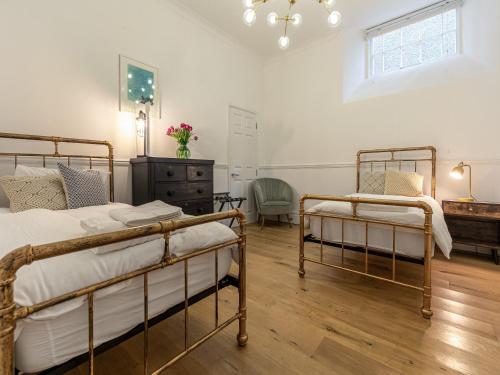 a bedroom with two bunk beds and a dresser at The Old Chapel in Saint Columb Minor