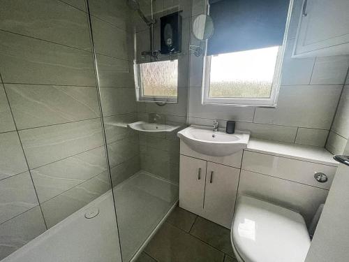 a bathroom with a toilet and a sink at Beautiful Chalet In The Seaside Village Of Scratby, Norfolk Ref 51054s in Great Yarmouth
