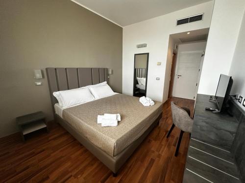 a bedroom with a bed with two towels on it at Hotel Golden in Rimini