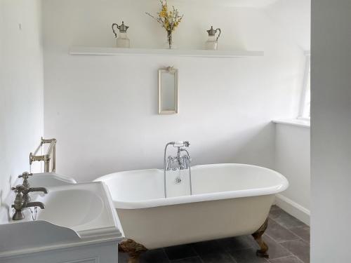 a white bathroom with a tub and a sink at Ashford Old Farm in Ilton