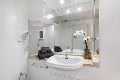 a white bathroom with a sink and a tub at Albufeira Haven 103 in Albufeira