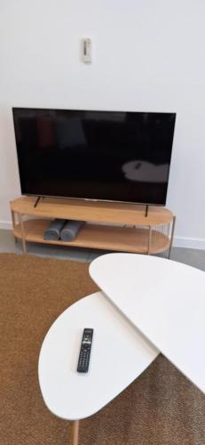 a table with a surfboard and a tv at Huis ALNA 5 in Mechelen