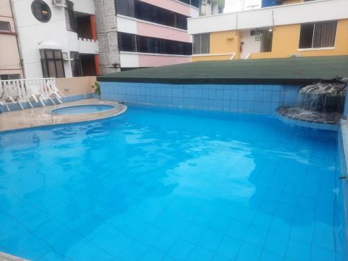 a large blue swimming pool in a building at Hotel Carmita in Atacames