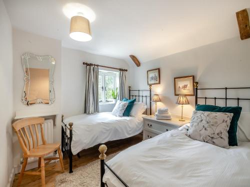 a bedroom with two beds and a desk and a mirror at Swallow Cottages, No, 2 - Uk46810 in Thurgarton
