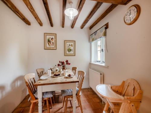 a dining room with a table and chairs and a clock at Swallow Cottages, No 1 - Uk46811 in Thurgarton